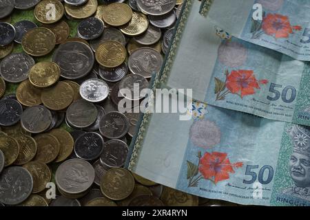 Terengganu, Malaysia - 24. August 2024 : Nahaufnahme von verstreuten malaysischen Münzen und 50 Ringgit malaysischem Geld Stockfoto