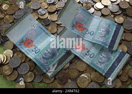 Terengganu, Malaysia - 24. August 2024 : Nahaufnahme von verstreuten malaysischen Münzen und 50 Ringgit malaysischem Geld Stockfoto