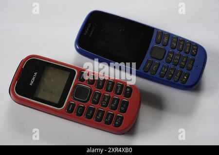 Terengganu, Malaysia - 24. August 2024 : Nahaufnahme zweier nokia-Tastaturtelefone auf isoliertem Hintergrund. Blaue und rote Farben. Stockfoto