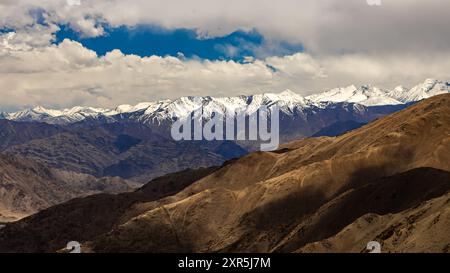 Ein Panoramablick auf schneebedeckte Bergketten mit Wolken am Himmel bei Ladakh Stockfoto