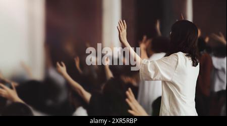 Leidenschaftliche Christen mit den Händen, die im Gebet erhoben wurden, mit dem Heiligen Geist erfüllter Gottesdienst und kirchlicher Umgebung Stockfoto