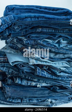 Der Stapel des Stapels der alten Jeans verschiedene Schattierungen der blauen Jeans. Denim-Jeans-Struktur. Denim-Hintergrundtextur für Design. Denim-Struktur in Canvas. Blauer Denim Stockfoto