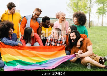 Die Menschen feiern eine Regenbogenparty mit schwuler LGBTQ-Flagge am Sommertag in Park City. Konzentrieren Sie sich auf schwarze Frauen. Diversitätskonzept Stockfoto