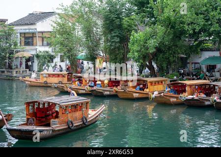 Suzhou, China - 11. Juni 2024 : Holzboote säumen die Kanäle von Suzhou, China. Stockfoto