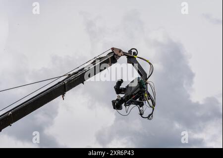 Kino- und Fernsehkamera hängt an einem Rundfunkkran mit dem bewölkten Himmel im Hintergrund Stockfoto