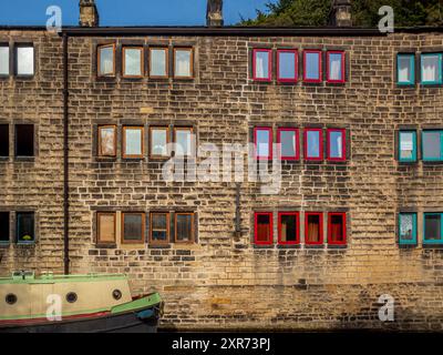 Eine Reihe von Reihenhäusern mit Blick auf den Fluss Calder und die Hebden Bridge. West Yorkshire, Großbritannien Stockfoto