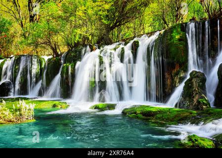 Fantastischer Wasserfall und azurblauer See mit kristallklarem Wasser Stockfoto