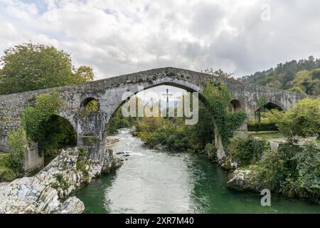 Römische Brücke in der Stadt Cangas de Onis, Spanien mit dem Siegeskreuz, das am Bogen hängt Stockfoto