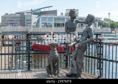 "People Like US" Bronzeskulptur von Mann, Frau und Hund von John Clinch am Mermaid Quay, Cardiff Bay, Cardiff, Großbritannien. Stockfoto