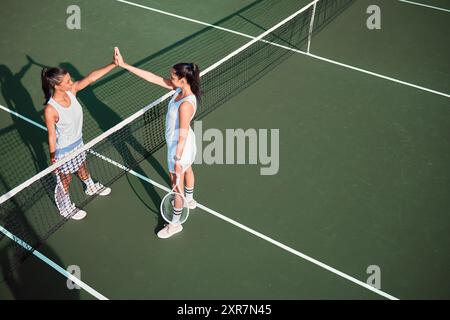 Platz, Tennis und Frauen mit High 5 für Sport, Wettbewerb und Spiel Herausforderung mit Dankeschön. Outdoor, Athleten oder Menschen mit Händen feiern Stockfoto