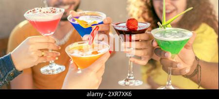 Junge Freunde, die Spaß haben, Cocktails an der Bar zu trinken - Leute, die bunte Cocktails trinken - Partyzeit und Freundschaftskonzept Stockfoto