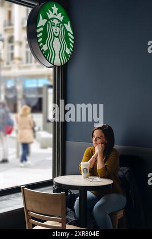 MADRID, SPANIEN - 08. APRIL 2021: Frau macht eine Pause im Starbucks Coffee Shop. Stockfoto