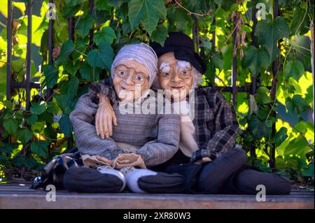 Tiflis, Georgien - 8. Oktober 2023: Lebensgroße Porzellanpuppen, die ältere Paare zeigen, die sich im Garten auf dem Tiflis Flohmarkt entspannen Stockfoto