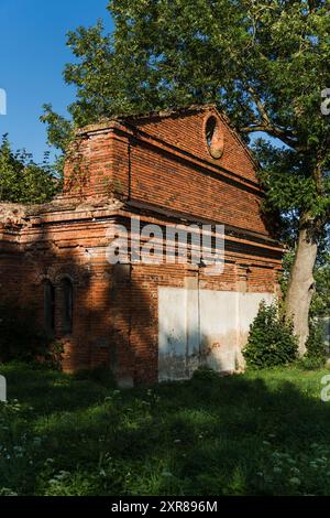 Ein ruinierter roter Ziegelstall. Das Gutshaus Kostrovitski. Gebäude aus dem 19. Jahrhundert Stockfoto