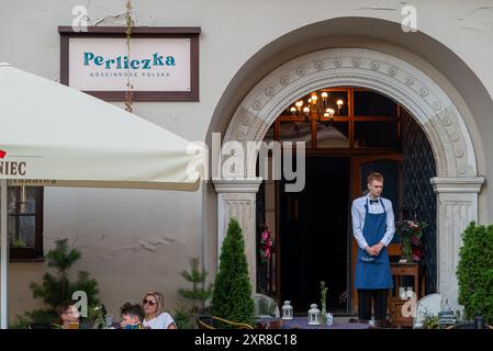 Lublin, Polen 26. Juli 2024 Kellner, der in der Tür zu einem eleganten Restaurant 'Przepioreczka' steht und auf Besucher wartet Stockfoto