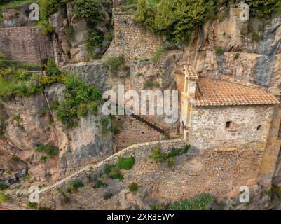 Aus der Vogelperspektive der Kirche Santa Maria de Montgrony, eingebettet in die Felsen und Klippen des Montgrony-Gebirges (Ripollès, Girona, Katalonien Spanien) Stockfoto