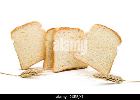 Weißbrotscheiben mit Weizenohren auf weißem Hintergrund. Stockfoto