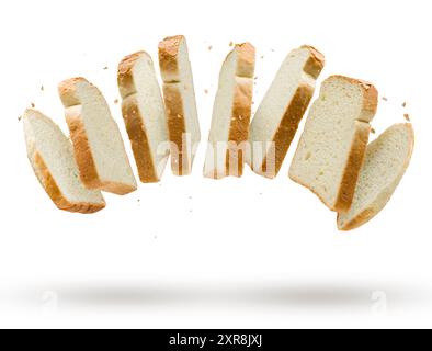 Weiße Brotscheiben, die mit Brotkrumen auf weißem Hintergrund fliegen. Stockfoto