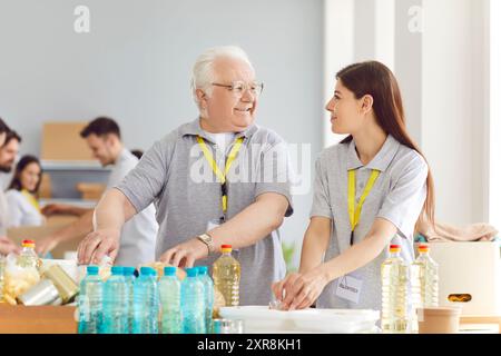 Ein Team von Freiwilligen packt Lebensmittel in Spendenkiste für wohltätige Lebensmittel. Stockfoto