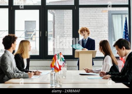 Teenager hören aufmerksam auf der Model UN-Konferenz zu, während ein Kollege eine Rede hält. Stockfoto