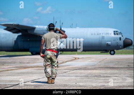 Technik. Sgt. Cruz George, engagierter Crew-Chef der 803. Flugzeugwartungsstaffel, grüßt die Piloten eines C-130J Super Herkules vor dem Start in Ke Stockfoto