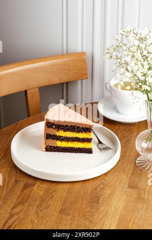Ein Stück Schokoladenkuchen auf einem weißen Teller, Tee in einer Tasse Stockfoto