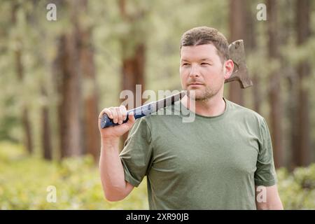 Nahaufnahme eines Menschen mit einer Axt im Wald Stockfoto