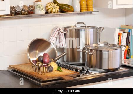 Küchenszene mit Töpfen, Kartoffeln und Kochutensilien Stockfoto