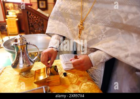 Der orthodoxe Priester bereitet sich auf das Taufritual vor Stockfoto