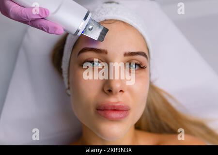 Gesichtsreinigung mit Ultraschall-Scrubber. Frau erhält Ultraschall-Gesichtspeeling und -Reinigung. Kosmetik- und Gesichtspflege. Gesichtsbehandlung Stockfoto