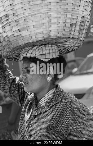 Frau mit einem Korb auf dem Kopf Goa India. Indianerin mit großem Korb auf dem Kopf. In Indien ist das ein beliebter Weg, schwere Dinge zu bringen. Hart Stockfoto