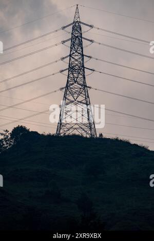 Ein Übertragungskraftturm mit Hochspannungsdrähten auf einem Hügel in Himachal Pradesh, Indien, in der Nähe des Kraftwerks Chamera. Stockfoto