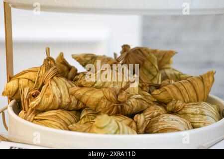 Ketupat Palas oder Reisknödel, gekochter klebriger Reis mit Kokosmilch in Hülle aus jungen Kokosblättern. Stockfoto