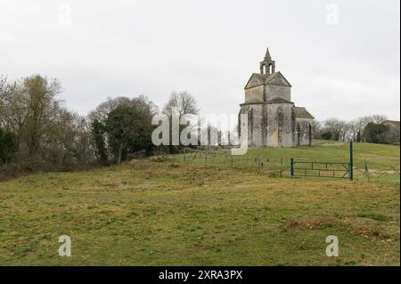 Arles, Frankreich - 8. März 2023: Chapelle de la Sainte Croix an einem bewölkten Morgen im Winter, roter Traktor Stockfoto