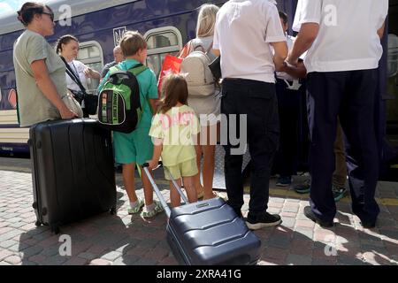 CHARKIW, UKRAINE - 8. AUGUST 2024 - Passagiere steigen in den ersten Kinderzugwagen, der vom Kinderhilfswerk der Vereinten Nationen (UNICEF) und der ukrainischen staatlichen Eisenbahngesellschaft Ukrzaliznytsia auf der Strecke Charkiv-Yasinia als Teil des Zuges N15/16 in Charkiw, Nordostukraine gestartet wurde. Stockfoto