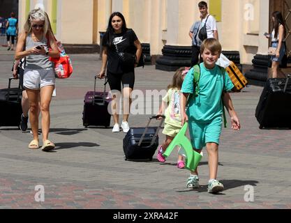 CHARKIW, UKRAINE - 8. AUGUST 2024 - Passagiere gehen auf dem Bahnsteig an Bord des ersten Kinderzugwagens, der vom Kinderhilfswerk der Vereinten Nationen (UNICEF) und der ukrainischen staatlichen Eisenbahngesellschaft Ukrzaliznytsia auf der Strecke Charkiw-Yasinia als Teil des Zuges N15/16 in Charkiw, Nordostukraine gestartet wurde. Stockfoto