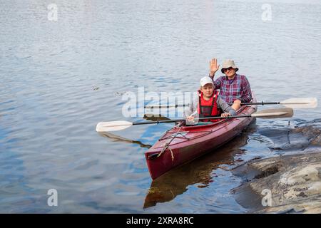 Vater und Sohn beginnen mit dem Kajak mit Paddeln, Kajak fahren, Kanu fahren, Boot fahren in der Ostsee während der Familienurlaube in Finnland, hori Stockfoto