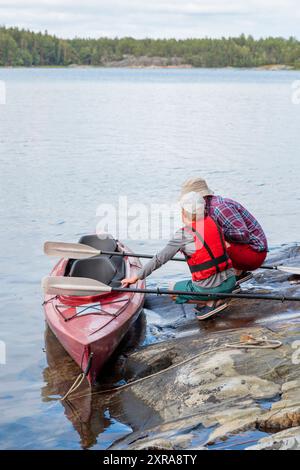 Vater unterrichtet seinen Sohn für Kajakfahren am Meer mit Paddeln zum Kajakfahren am Meer, Kanu fahren, Bootfahren in der Ostsee während der Familienferien Stockfoto