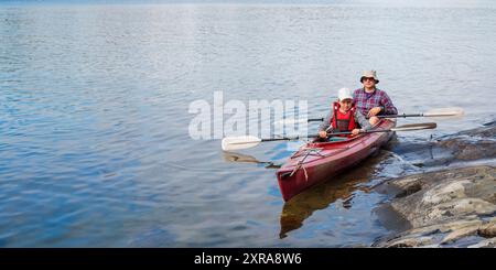 Vater und Sohn beginnen mit dem Kajak mit Paddeln, Kajak fahren, Kanu fahren, Boot fahren in der Ostsee während der Familienurlaube in Finnland, bann Stockfoto