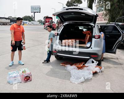 Chalco, Mexiko. August 2024. Während der Blockade auf der Autobahn Mexiko-Puebla gaben einige Leute Nahrung an Anhänger-Fahrer, um die Stunden, die sie am 8. August 2024 in Chalco, Bundesstaat Mexiko, in der Blockade feststeckten, besser zu verbringen. (Foto: Josue Perez/SIPA USA) Credit: SIPA USA/Alamy Live News Stockfoto