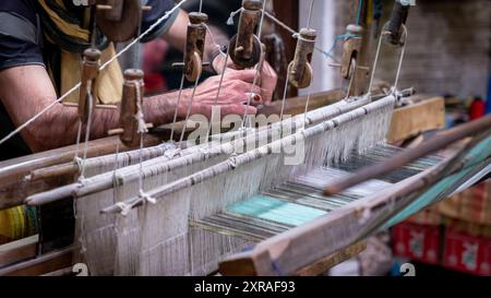 Kashan, Iran - 28. April 2019: Iranischer Mann, der in der Teppichwerkstatt einen Teppich an den Baumwollfäden bastelt Stockfoto