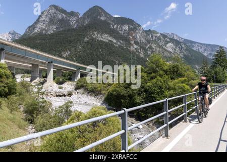 Frau mit E-Bike auf der alpe adria Radroute ( Pontebanna ) durch das Val Canale in Italien Stockfoto