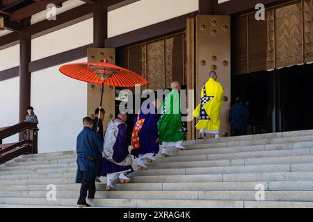Narita, Japan - 23. Juli 2024: Priester gehen an einem sonnigen Sommertag in Richtung der Haupthalle des Naritasan Shinsho-JI-Tempels in der Nähe von Tokio Stockfoto
