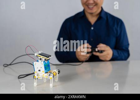 Der Lehrer sammelt einen handgefertigten Metall- und Plastikroboter. MINT-Ausbildung für Kinder und Jugendliche, Robotik und Elektronik. HEIMWERKER AI. DAMPFKONZEPT. Stockfoto