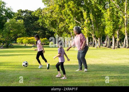 Eine gesunde und glückliche Großmutter mit ihrer Enkelin spielt Fußball im Park. Das Konzept eines Großelterns, der Freizeit mit einer Grandda verbringt Stockfoto