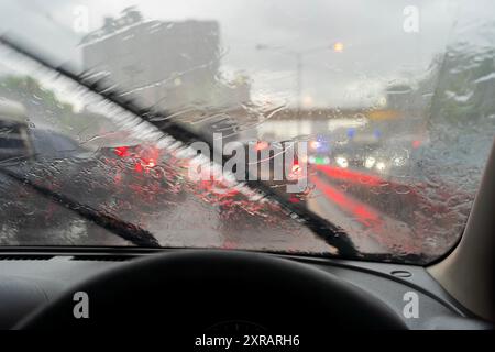 Starker Regen, Sicht ist schwierig. Schalten Sie den Scheibenwischer ein, um das Problem zu lösen. Damit du die Vorderseite sehen kannst. Das Problem ist ein Stau im Verkehr Stockfoto