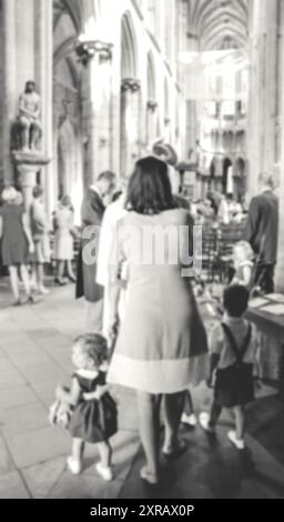 Verschwommenes Foto von Menschen, die sich zur Hochzeitszeremonie in der gotischen Kirche versammelten. Frankreich. Schwarz-weiß. Stockfoto