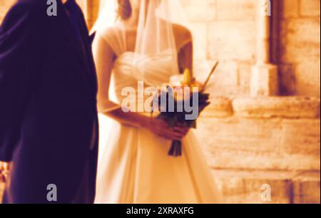 Verschwommenes Foto von Braut und Vater, die warten, bevor sie die gotische Kirche am Hochzeitstag betreten (Vater bringt seine kleine Tochter zum Altar). Stockfoto