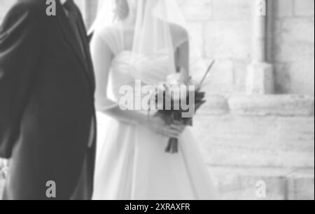 Verschwommenes Foto von Braut und Vater, die warten, bevor sie die gotische Kirche am Hochzeitstag betreten (Vater bringt seine kleine Tochter zum Altar). Stockfoto