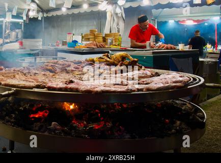 Köche in der Cocina de Galicia unter einem Festzelt mit einem großen Feuer und Fleischkochen während der Semana Grande öffentlichen Veranstaltung Santander Cantabria Spanien Stockfoto